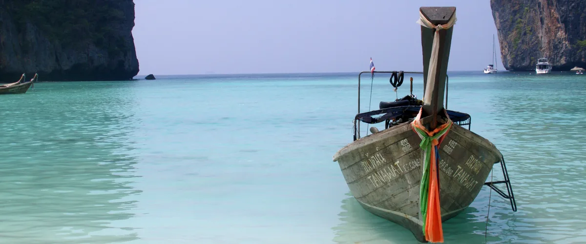 Tropical island-hopping boat expedition across turquoise waters and dramatic limestone karst cliffs in Thailand
